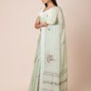Model wearing a light green pure crepe saree with intricate floral embroidery, perfect for festive occasions