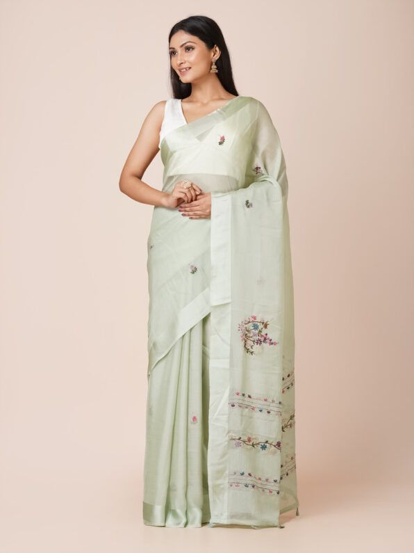 Model wearing a light green pure crepe saree with intricate floral embroidery, perfect for festive occasions