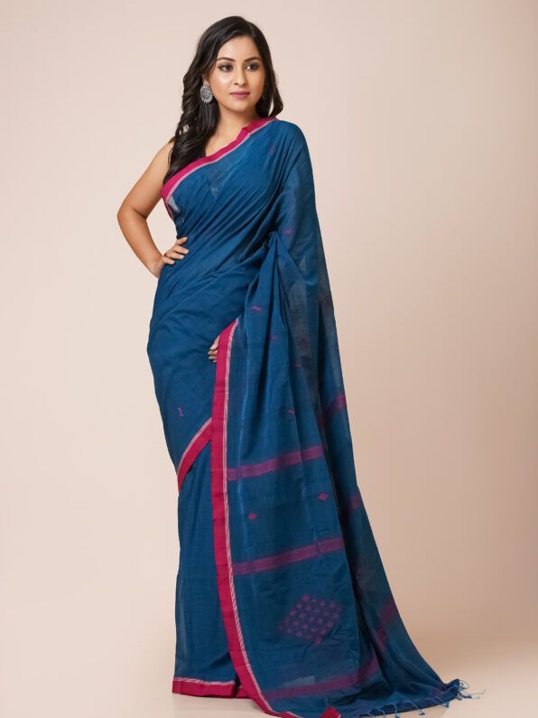 A deep blue khadi cotton saree with red and gold zari border and embroidered motifs.