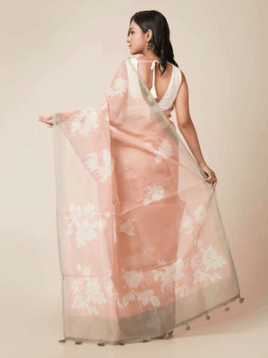Peach semi organza saree with hand embroidery, floral motifs, silver zari border, and beaded embellishments