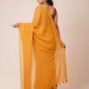 A woman showcasing a mustard yellow mul cotton saree with tassel details along the border. The saree is lightweight, breathable, and perfect for casual or daily wear.