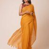 A woman showcasing a mustard yellow mul cotton saree with tassel details along the border. The saree is lightweight, breathable, and perfect for casual or daily wear.