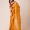 A woman showcasing a mustard yellow mul cotton saree with tassel details along the border. The saree is lightweight, breathable, and perfect for casual or daily wear.